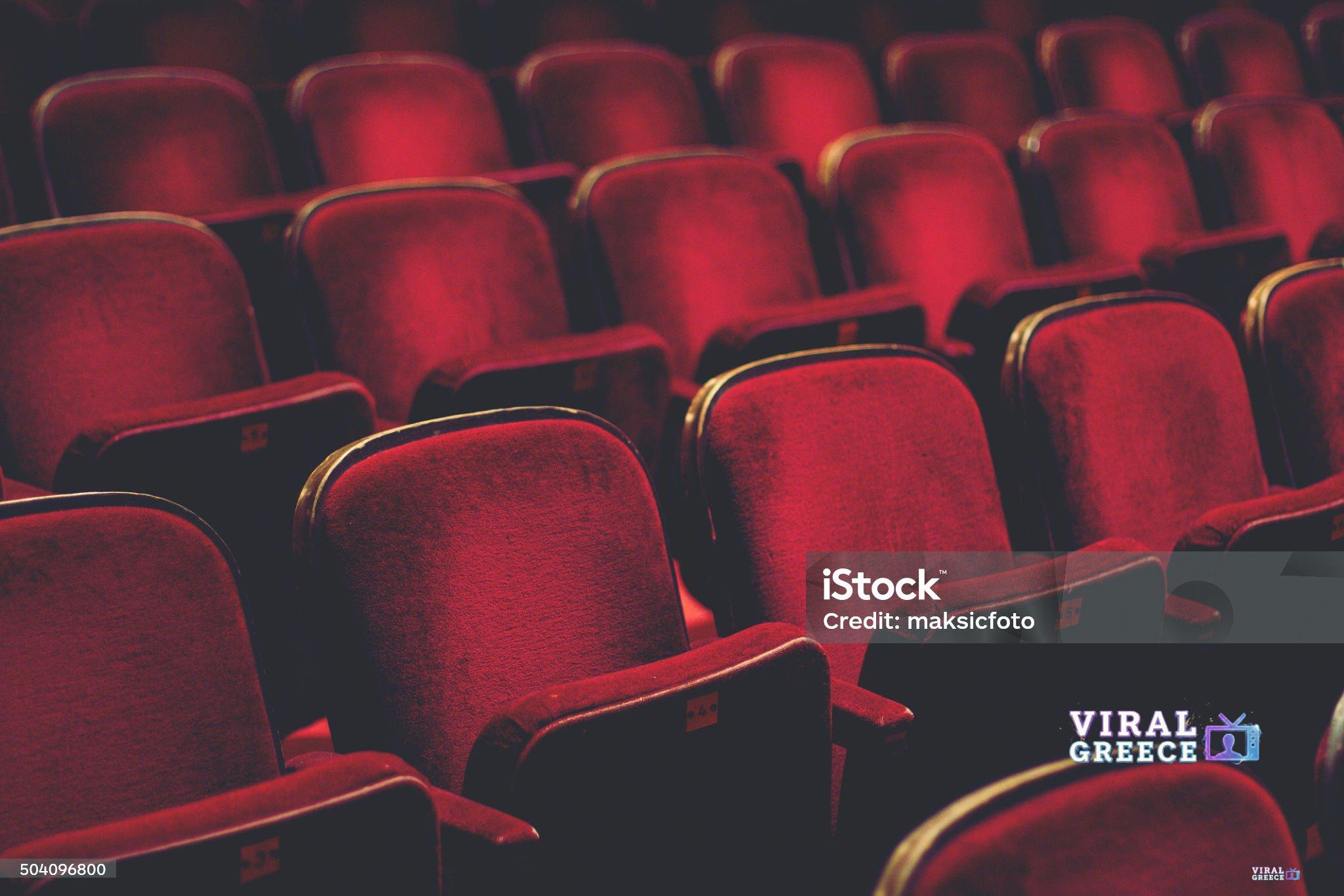 Empty comfortable red seats with numbers in cinema