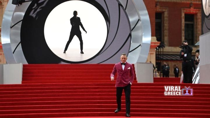 Ο Ντενί Βιλνέβ στη σκηνοθεσία του νέου James Bond – Η Amazon MGM Studios δίνει το στίγμα της επόμενης ταινίας 007 Ο Ντενί Βιλνέβ σε κόκκινο σακάκι μπροστά από σκηνικό με τον κωδικό 007 στο Cinema Con, με κόκκινες σκάλες.